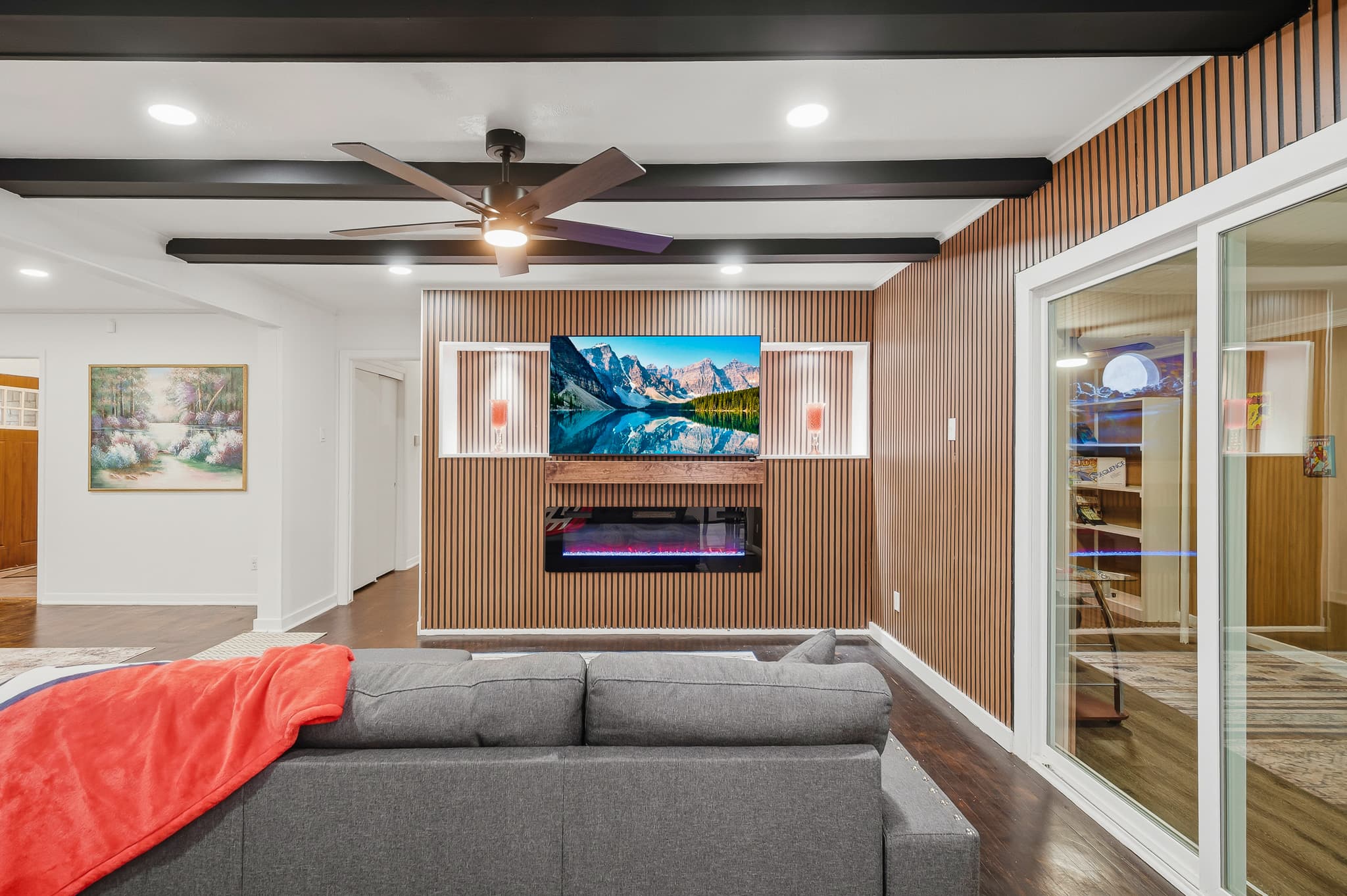 Den with a slatted wood wall, mounted television and long electric fire