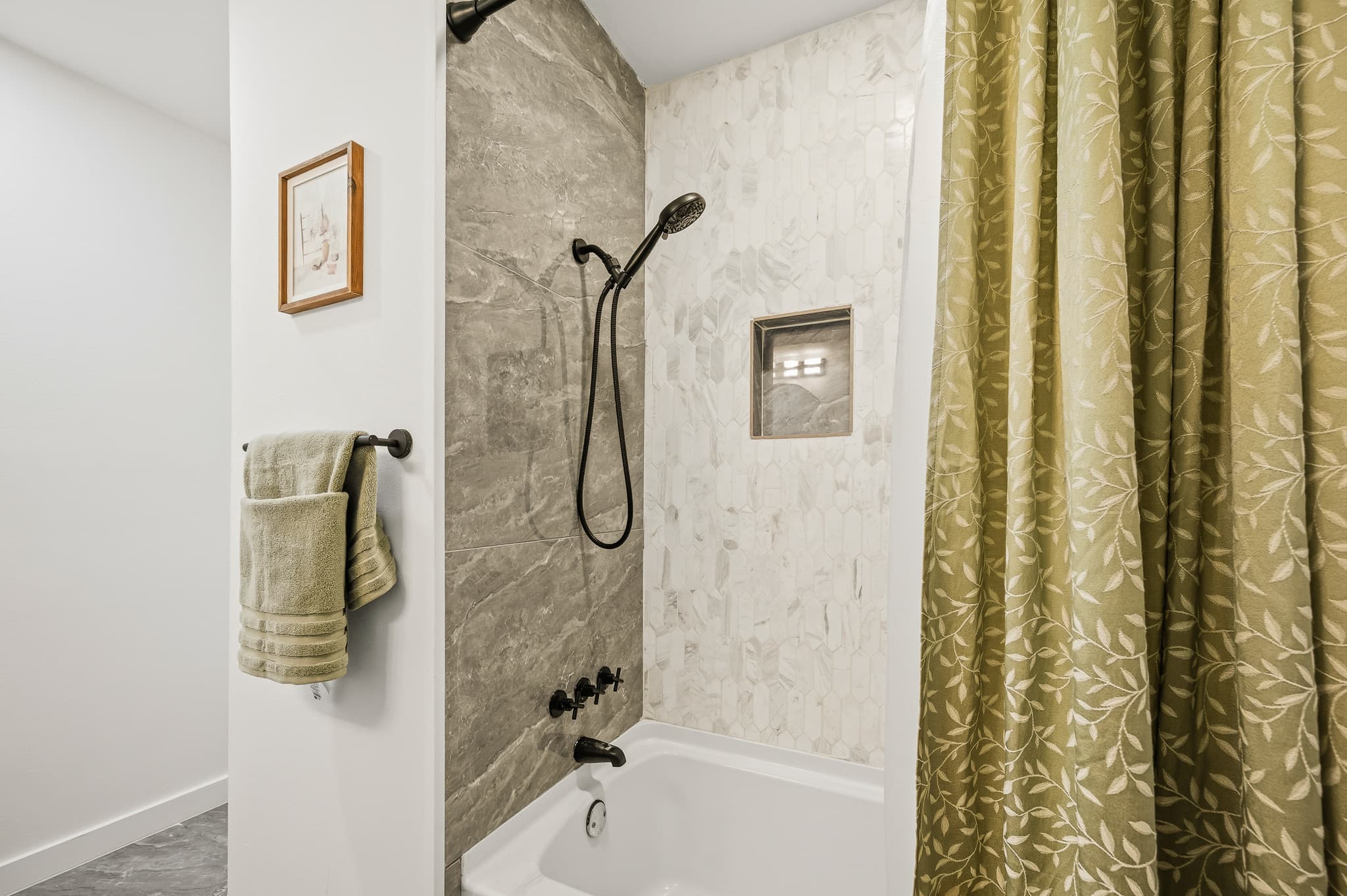 Bathroom with a tiled shower over the bath