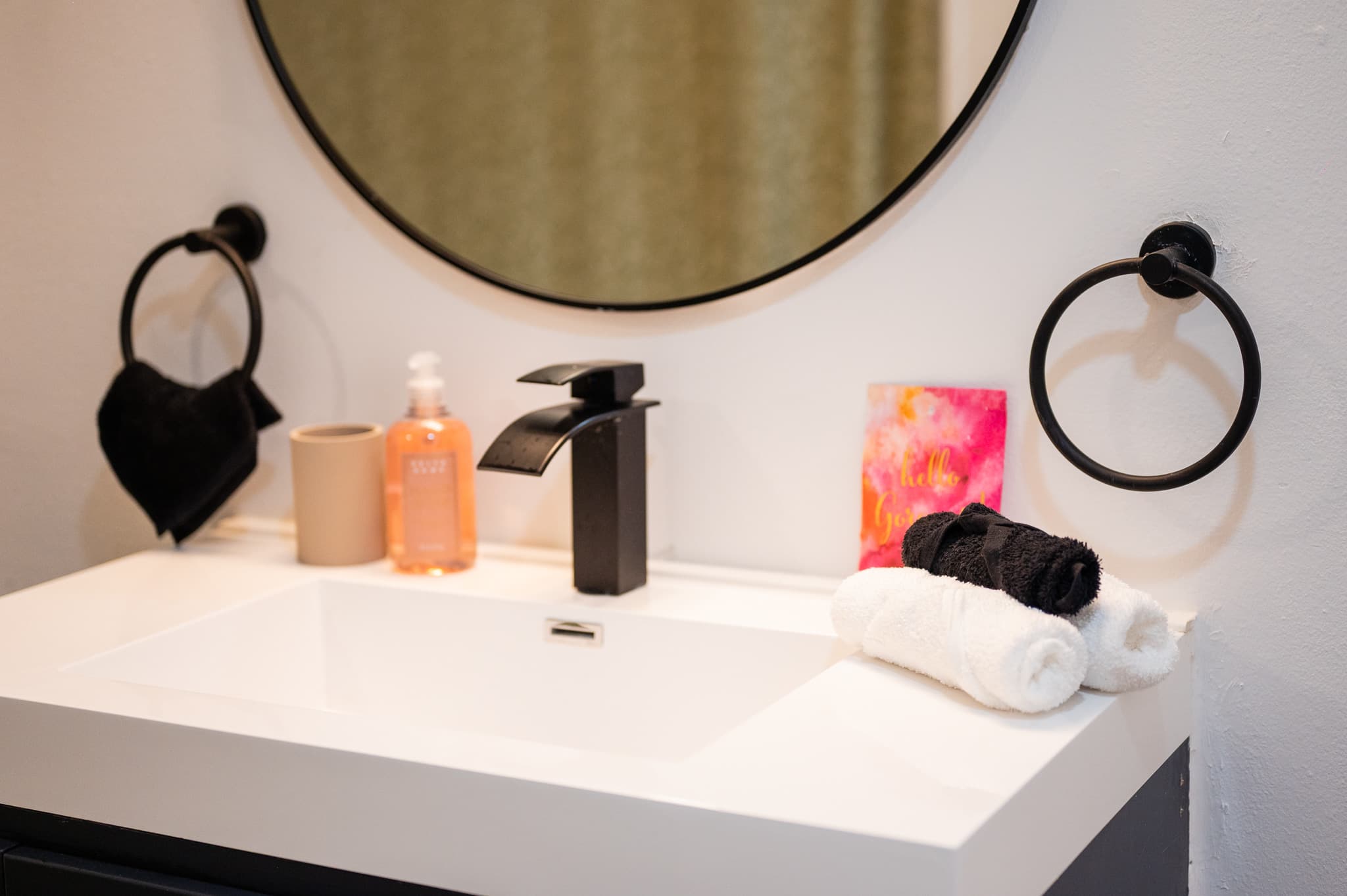 Washbasin with a round mirror and black fittings